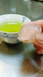 Close-up of hand holding ice cream on table