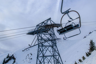 Low angle view of ski lift against sky during winter