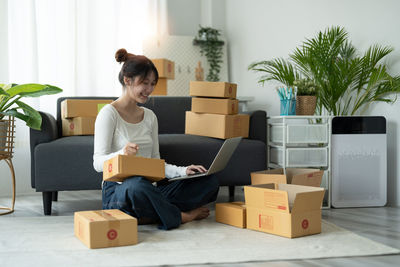 Side view of young woman using laptop while sitting at home