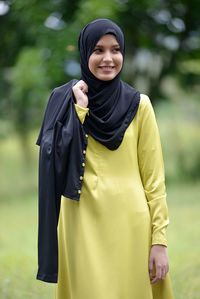 Portrait of a smiling young woman standing outdoors