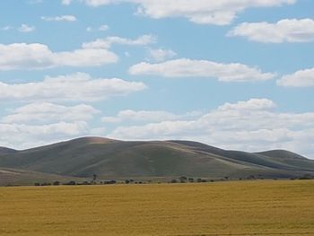 Scenic view of field and mountains against sky