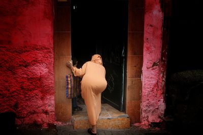 Woman standing against built structure