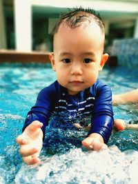 Cute baby boy calm and enjoying playing  water  in pool.