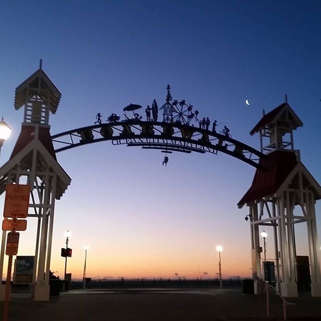 clear sky, sunset, built structure, blue, architecture, copy space, building exterior, communication, silhouette, outdoors, low angle view, sky, dusk, sunlight, illuminated, text, no people, lighting equipment, street light, guidance