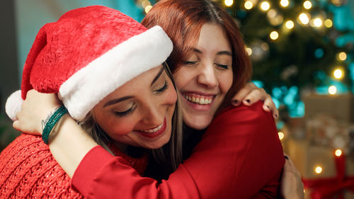 Portrait of smiling young woman wearing santa hat
