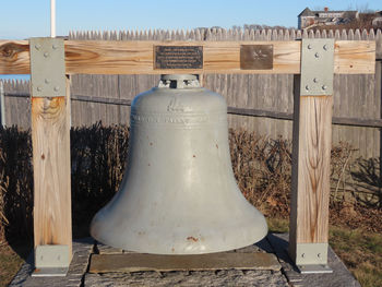 Close-up of metal fence on field against sky