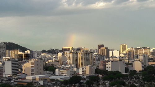 View of cityscape against cloudy sky