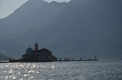 Scenic view of sea by mountains against sky