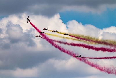 Low angle view of airshow against sky