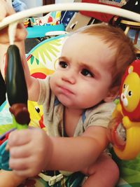 Portrait of cute baby boy holding toy