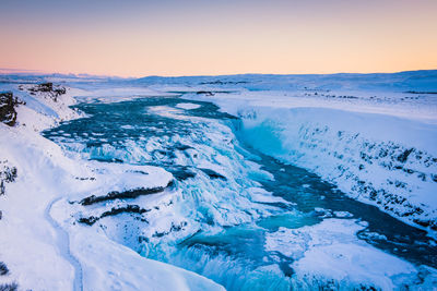 Scenic view of snowcapped mountains against sky during sunset