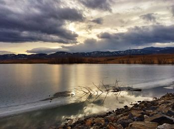 Scenic view of lake against cloudy sky