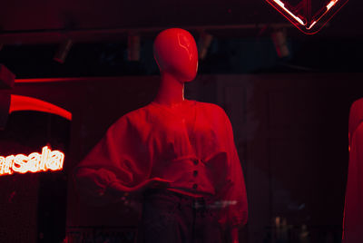 Rear view of man standing against illuminated wall