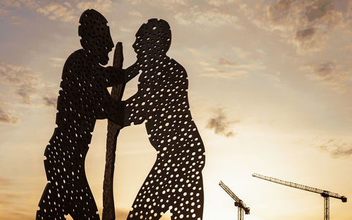 Silhouette woman standing against sky during sunset