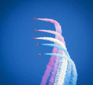 Low angle view of airplane flying against blue sky