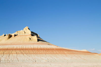 Scenic view of desert against clear blue sky