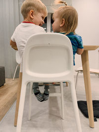 Rear view of the children sitting at the table at home