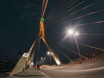 Low angle view of illuminated bridge against sky at night