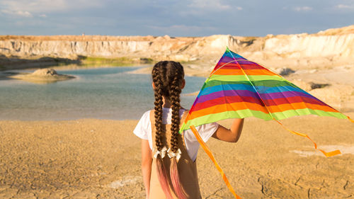 Rear view of woman with umbrella on beach