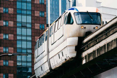 Low angle view of elevated train and modern buildings in city