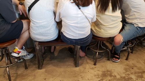 Low section of people sitting on chair