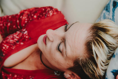 Close-up of woman relaxing on bed at home