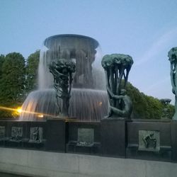 Statue by trees against clear sky