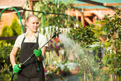 Woman with umbrella standing in yard