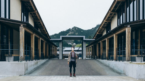 Man wearing mask standing in front of building