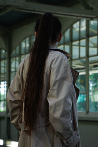 Rear view of woman standing in train