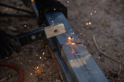 Midsection of man working on metal