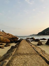 Surface level of rocks on beach against sky