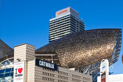 Low angle view of modern buildings against clear blue sky