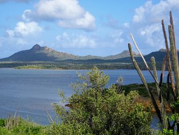 Scenic view of lake by mountains against sky