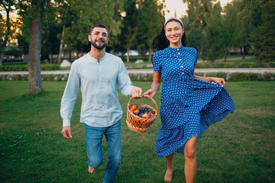 Full length of a smiling man holding ice cream in basket