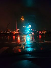 Illuminated city street during rainy season at night