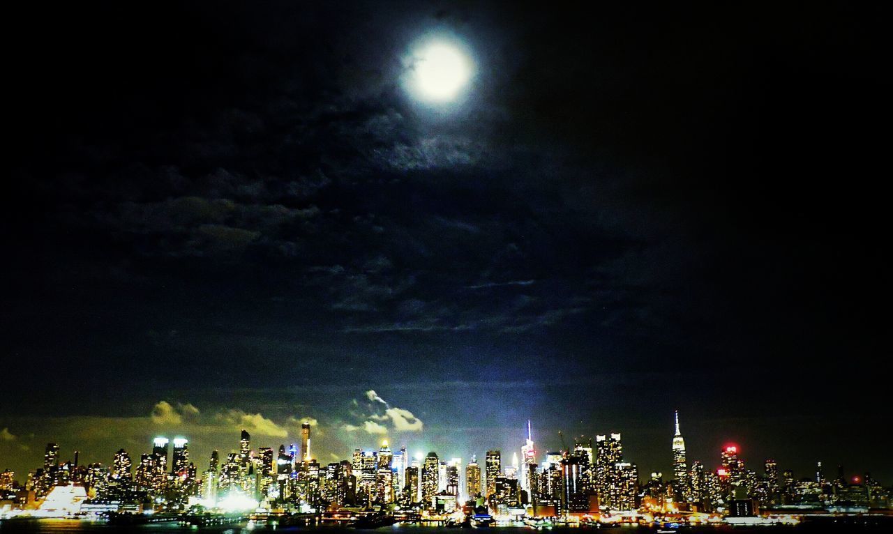 PANORAMIC VIEW OF ILLUMINATED CITY AGAINST SKY AT NIGHT