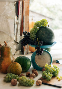 Autumn still life with pumpkins,walnuts,melons, watermelon and grapes on a scale to scale
