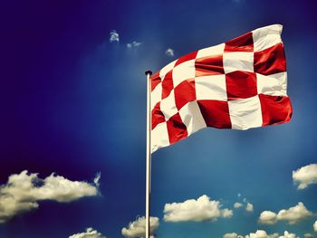 Low angle view of flag against blue sky