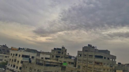 Buildings in city against sky at sunset