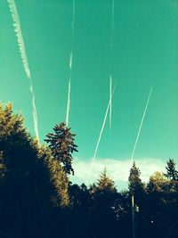 Low angle view of silhouette trees against blue sky