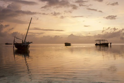 Boat in sea against sky during sunset