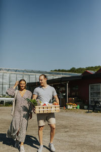 Smiling couple carrying shopping in crate