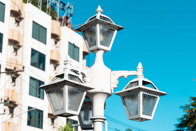 Low angle view of street light by building against sky