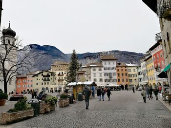 People walking on street in city against clear sky