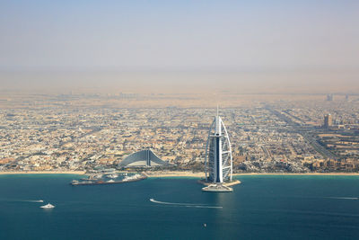 Sailboat in sea against sky in city