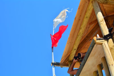 Low angle view of flag against clear blue sky