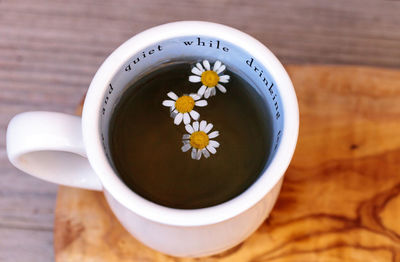 Close-up of white daisies in herbal tea on table