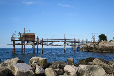 Pier over sea against blue sky