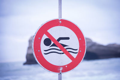 Close-up of road sign against sky